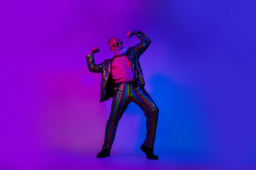 Fototapeta premium Full size photo of cool macho senior man show biceps dressed colorful sequins striped garment isolated on blue purple neon light background