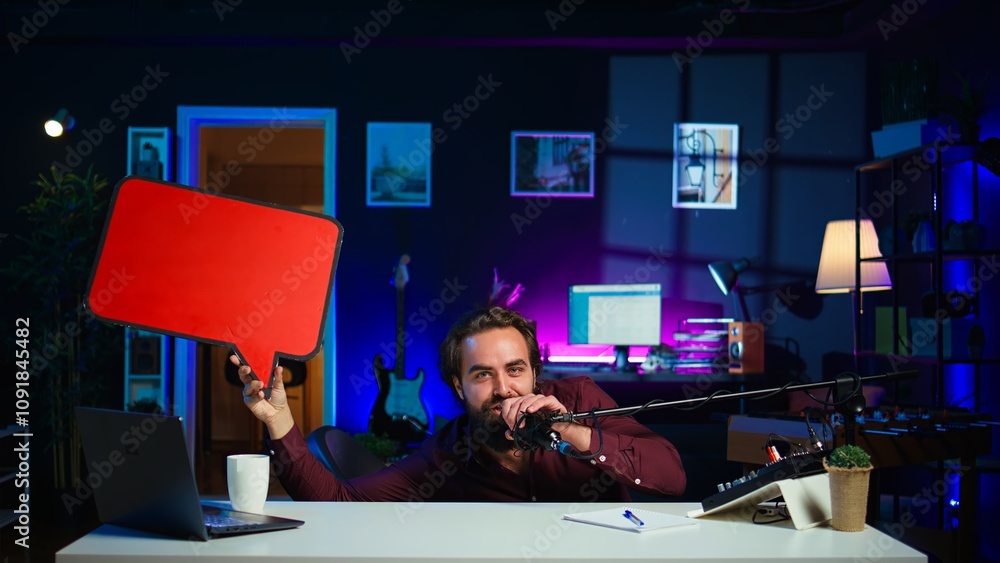 Poster playful influencer hiding under desk, pointing to empty copy space sign. jolly content creator using
