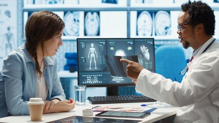 African american physician presenting the x ray diagnostics results to a patient, examining the...