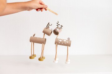 controlling DIY reindeer puppets made from cardboard tubes and bottle caps. Christmas and winter...