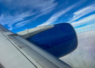 View Of Jet Engine In Flight Above The Clouds With Blue Sky