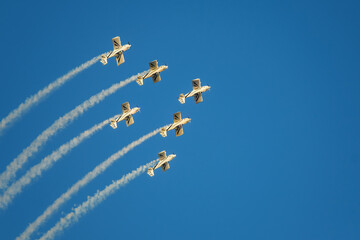 Stunt aerobatic planes in inverted flight performing stunts in blue sky with smoke trail. Concept...