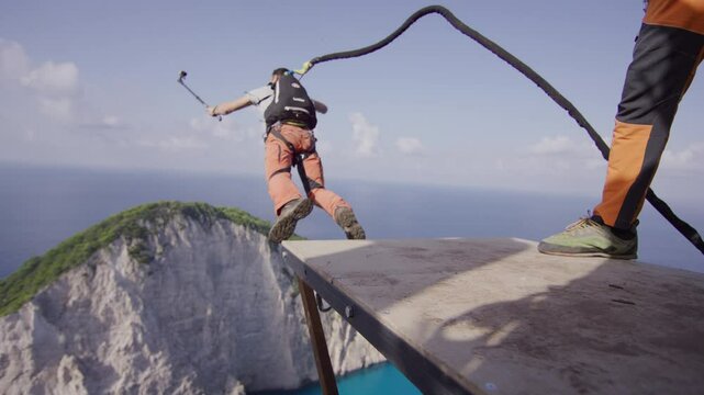 Man with gopro leaping off plank on Greece cliff - slow motion