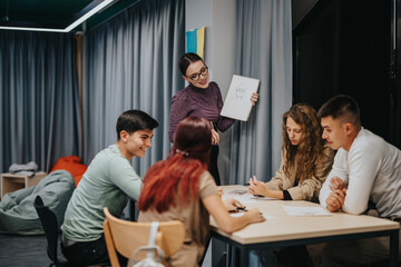 Obraz premium An art teacher enthusiastically shares drawing techniques with attentive students in a creative classroom setting. The students are engaged in learning and exchanging ideas during a dynamic group