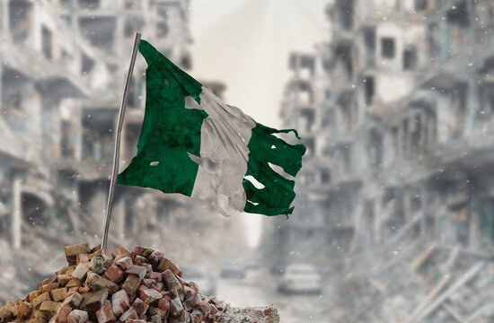 Dirty and torn Nigeria flag, symbol of resistance and victory. A scene of war and devastation, the ruins of a city destroyed by conflicts. 3D Rendering.