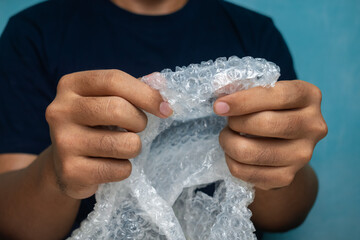 male hands popping bubble wrap to releasing stress