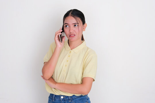 A woman showing annoyed expression when answering a phone call