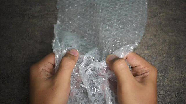 male hands popping bubble wrap to releasing stress