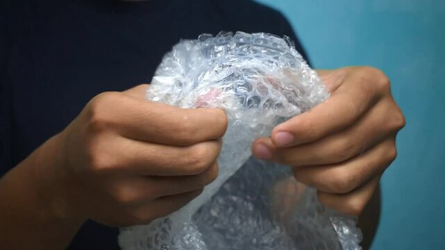 male hands popping bubble wrap to releasing stress