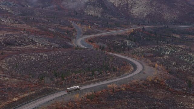 Truck Driving Over Dempster Highway Through Ogilvie Mountains During Autumn In Yukon, Canada. Aerial Drone Shot