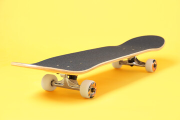 One skateboard on yellow background, closeup. Sports equipment © New Africa