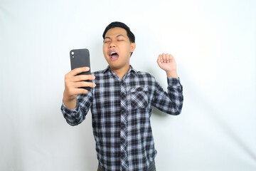 sleepy asian man holding mobile phone yawning feels tired isolated on white