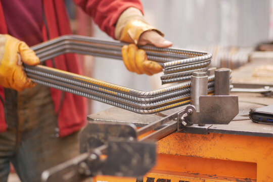 A skilled craftsman meticulously shaping metal using a clamp, set in a dynamic workshop environment