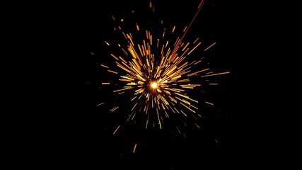Fototapeta premium Small fire sparks radiating from a central point on a dark surface, pyrotechnic, smoldering ember
