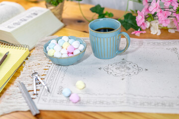 テーブルの上に勉強道具と共に準備されたカラフルなラムネとコーヒー