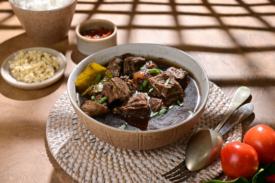Rawon known as Indonesian Traditional Beff Black Soup from  Java. Served on a Bowl with rice and chilli paste (sambal).