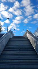Fototapeta premium Elevated Outdoor Metal Stairs Leading to the Sky Under Bright Blue Clouds