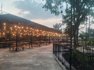 Obraz premium Outdoor dining area with string lights and picnic-style seating.