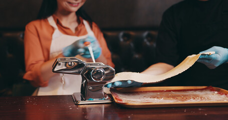 Woman, dough and meal prep with noodle cutter, cooking class and chef in Japanese restaurant for lunch. People, together and culinary skills as customer in hospitality, diet and healthy food for dish