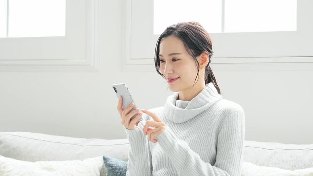 スマホ、女性、スマートフォン、悩む、困る、日本人、アプリ、がっかり、落ち込む、イライラ、トラブル、問題、ニュース、フェイクニュース、詐欺、悔しい、嫉妬、残念、失敗、故障、電波障害、インターネット、オンライン、web、インテリア、室内、悩み、怒る、既読スルー、SNS、メール、検索、ソーシャルメディア、表情、ブルー、ライフスタイル、ゲーム、ファッション、ニット、秋冬、カジュアル、じれったい、動画、感動