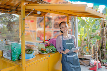 A cheerful vendor stands at a vibrant market stall, ready to serve fresh produce.