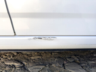 Scratched car door paint with rust spot close-Up