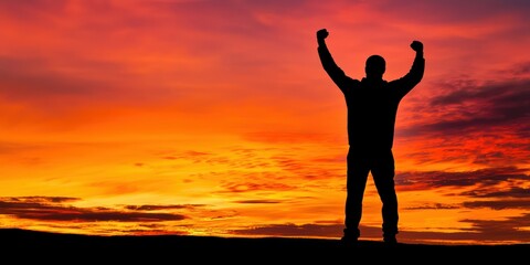 A silhouette of a man raising his fist in the air, standing tall against the background of a glowing sunset on Juneteenth.