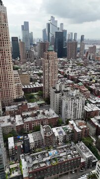 A stunning vertical orientation drone pull-away shot of W 52nd Street in New York City, showcasing the vibrant urban landscape, skyscrapers, and bustling city life in Manhattan.