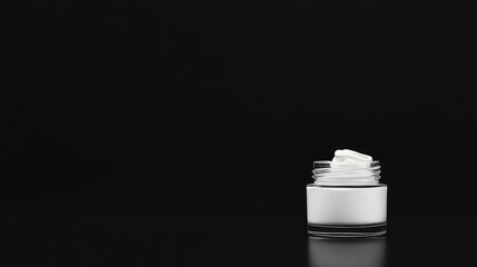 glass jar with swirl white lotion Over black Studio Background.