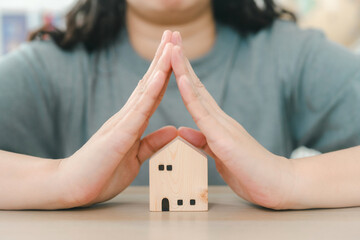 Hands Protecting a Wooden House Model. Symbolizing Home Security, Insurance, Safety, Business, Architect, and Real Estate Concepts in Minimalist.