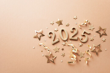Creative Christmas and New Year composition with golden party streamers, confetti stars and 2025...