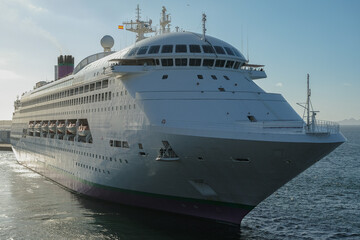 Classic cruiseship cruise ship liner Ambience sail away departure from Vigo port, Spain in Galicia during summer Atlantic Coast cruising with blue sky and coast line