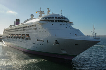 Classic cruiseship cruise ship liner Ambience sail away departure from Vigo port, Spain in Galicia during summer Atlantic Coast cruising with blue sky and coast line