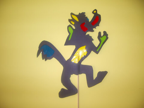 Lobo feito em papel e plastico colorido, usado para fazer um teatro.