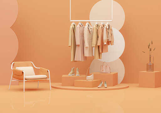 Autumn Clothes hanging on a rack with pastel orange background. Coat, sweater, warm shirt hanging on the hangers. Creative composition. Sale concep