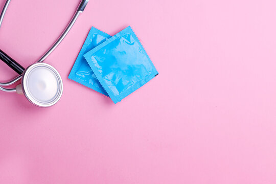 Flat Lay of Medical Equipment Condom in Pack and Stethoscope Isolated on Pink Background