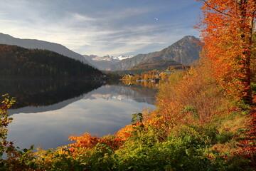 Naklejka premium Colorful Autumn scenery and reflections on the lake Altausseer See in Altaussee, Bad Aussee, Salzkammergut, Styria, Austria, Europe, with the mountains and the Dachstein in the background