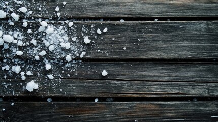 Fototapeta premium Sea salt scattered across a rustic, weathered wooden surface with deep cracks and a rich texture, creating a natural and organic feel.