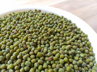 green peas in a bowl. raw green beans in white bowl on wooden background. healthy food. secondary crops. Mung Bean. Close up