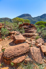 A jumble of boulders and rocks on a hiking trail through semi arid low tree country below the...