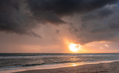 Heavy rain clouds at sunset hour by the sea in November as seen at the beach in Pervolia village, Larnaka District, Cyprus