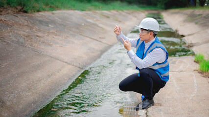 Expert biologists are checking the cleanliness of industrial water and collecting samples to test...