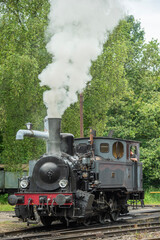 une ancienne locomotive à vapeur en fonction avec de la fumée qui sort de la cheminée 