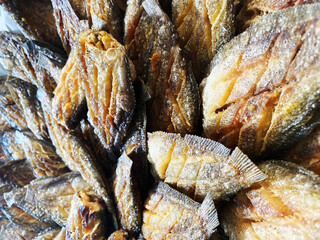 Deep fried Snakeskin gourami fish with spawns on white arches oil paper sheet