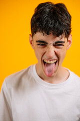 Teen boy sticking out tongue, playful, defiant expression.