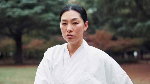 Martial arts, warrior and woman in forest, outdoor and serious for training, fighter and confident. Tradition, kenjutsu and keikogi for culture, Japanese person or discipline for performance in Japan