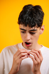 Teenager with freckles nervously fidgeting with fingers.