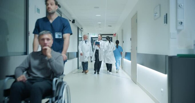 Busy Hospital Hallway with Doctors, Nurses and Specialists Preparing for the Day Ahead in Hospital. Female and Male Physicians, Surgeons, Healthcare Officials Walk Together in Corridor