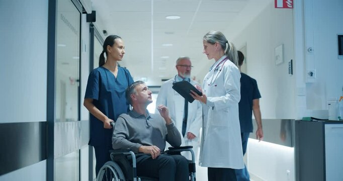 Cheerful Caucasian Female Doctor Engages with a Middle Aged Male Patient in a Wheelchair, Assisted by a Female Nurse in a Busy Hospital Hallway, Asking About Health and Talking About Test Results
