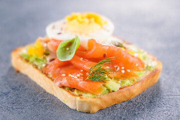 bread toast with avocado, salmon and egg